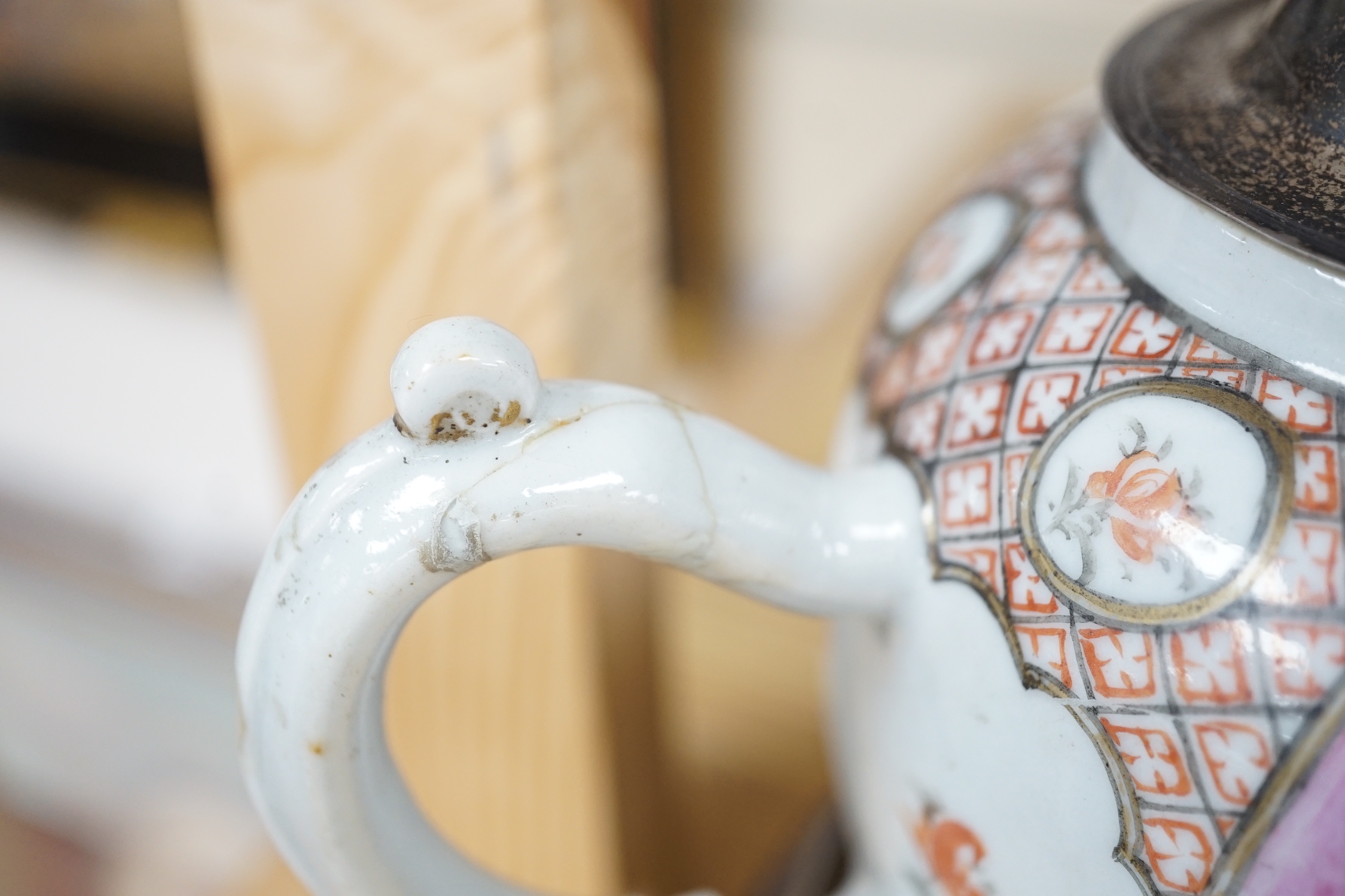 An 18th century Chinese export famille rose teapot with later silver spout and cover, on hardwood stand